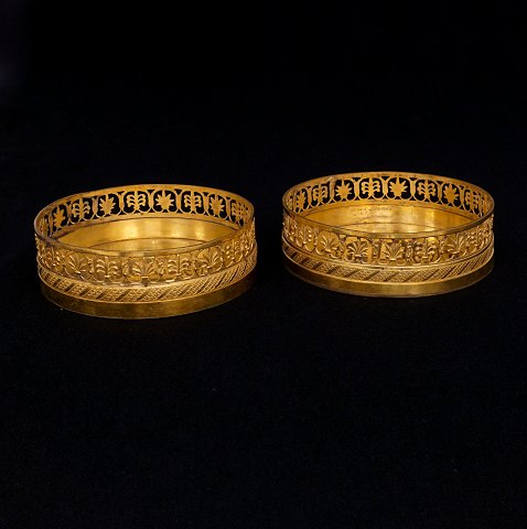 A pair of gilt coasters. France circa 1810. H: 
4cm. D: 13cm