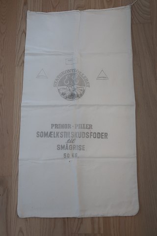 An old sack sæk from Denmark
Text: "Statskontrolleret Vitaminiseret - Primol - Piller - 
Somælkstilskudsfoder til smågrise - 25 kg"
96cm x 53cm
In a good condition
We have a good selection of old sacks, with or without different texts