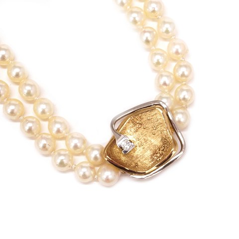 Ole Lynggaard lås til dobbeltradet halskæde i 14kt 
guld med brillant på ca. 0,1ct. Mål: 20x20mm