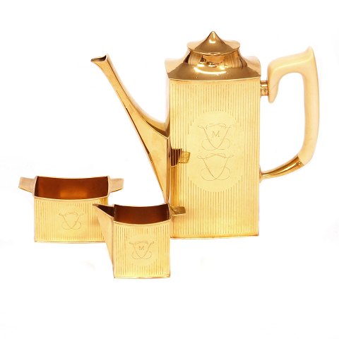 Hans Hansen kaffeservice udført i 18kt guld 
bestående af kande, sukker & flødesæt, 10 skeer og 
en sukkerske. Stemplet Hans Hansen og dateret 
1958. H kande: 17cm. Samlet vægt: 970gr