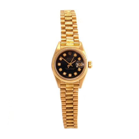 Rolex Oyster Perpetual Datejust ref. nr 69178 i 
18kt guld og sort skive med diamanter som 
timemarkører. D: 26mm. Leveres med boks, 
certifikat og købskvittering. Solgt første gang 
23/12 1985