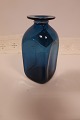 Vase fra Kastrup Vase fra Kastrup Glasværk
Fra Capri Serien, klart blåt glas
Blå vase med hals med krave
Design: Jacob E. Bang (1899-1965)
Produceret på Fyns Glasværk i 1961 (udgår af produktion i 1973)
H: ca. 15cm
Flot stand