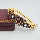 Antik 
Damgaard-
Lauritsen 
presents: 
Bangle of 
18k gold set 
with opal, a 
ruby, and blue 
enamel, 19th 
century
