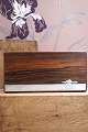 K&Co. presents: 
Oblong box 
in rosewood 
decorated with 
silver inlay 
with a motif of 
a small 
elephant 
carrying a ...