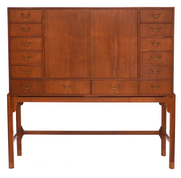 Skuffemøbel formgivet af Knud Juul Hansen udført i teak med i alt 14 skuffer og to låger foran opbevaringsrum. H: 160cm. B: 160cm. D: 50cm